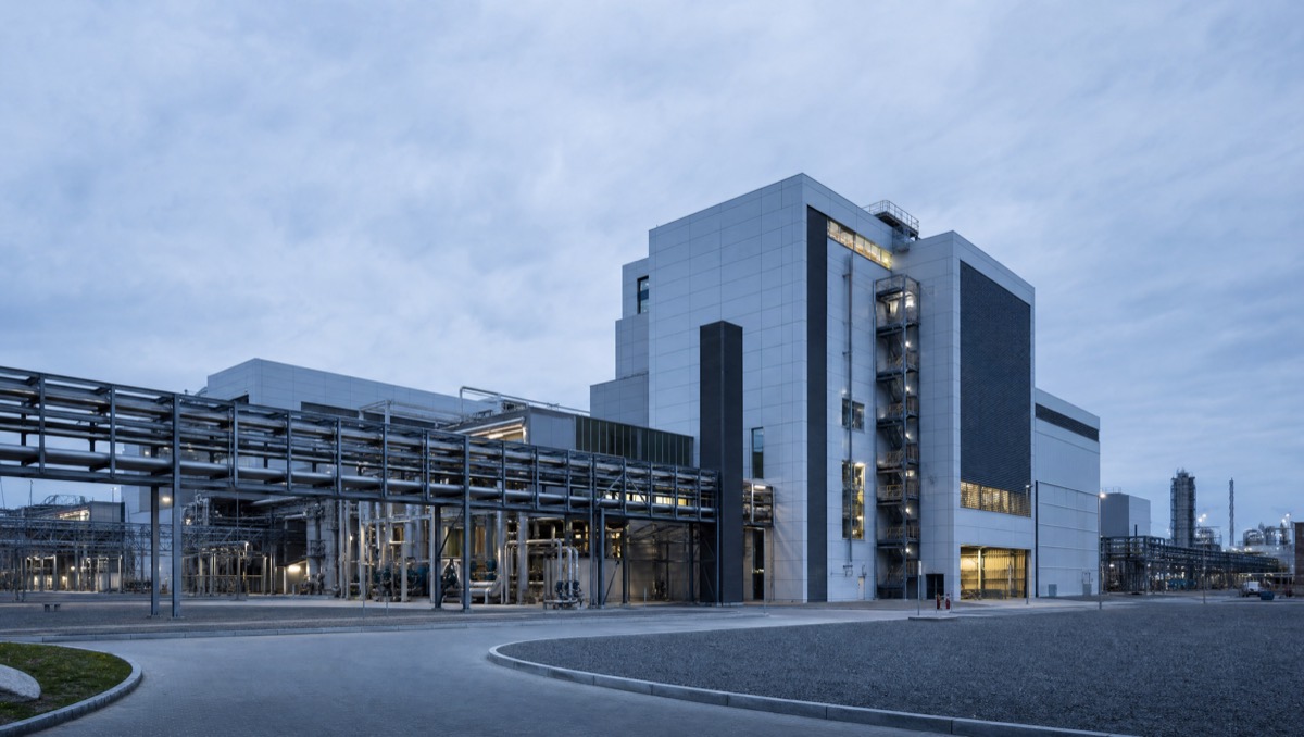 A large industrial process facility lit from within at blue hour.