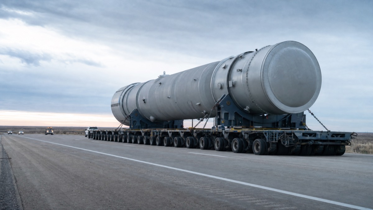 A large cylindrical industrial module secured on a multi-axle heavy-haul transporter.